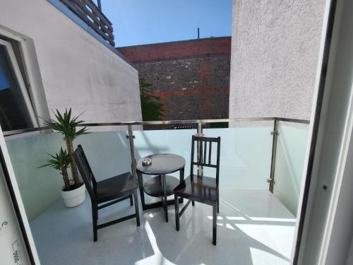 沃梅尔斯泰德Exquisite, gemütliche kleine Wohnung mit Balkon的阳台配有两把椅子和一张玻璃桌