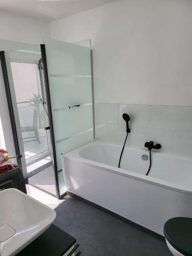 沃梅尔斯泰德Exquisite, gemütliche kleine Wohnung mit Balkon的白色的浴室设有浴缸和水槽。