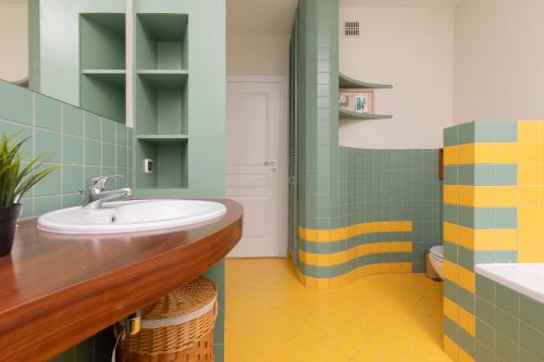 普鲁什库夫Spacious & Quiet 1 Bedroom Apartment in Pruszków by Renters的浴室设有水槽和绿色及黄色瓷砖