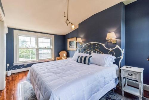 彼得斯堡Historic Petersburg Row Home的一间卧室配有一张带蓝色墙壁的大床