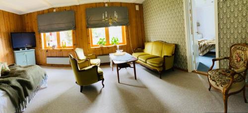 TrettenGlomstad Gjestehus的客厅配有沙发、椅子和桌子
