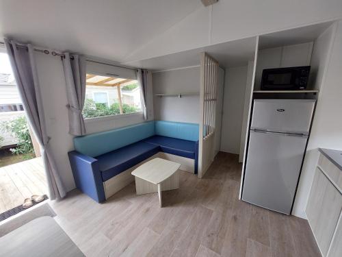 纳博讷普拉日Mobil Home (Clim, TV)- Camping Falaise Narbonne-Plage 4* - 003的小厨房配有蓝色的沙发和冰箱