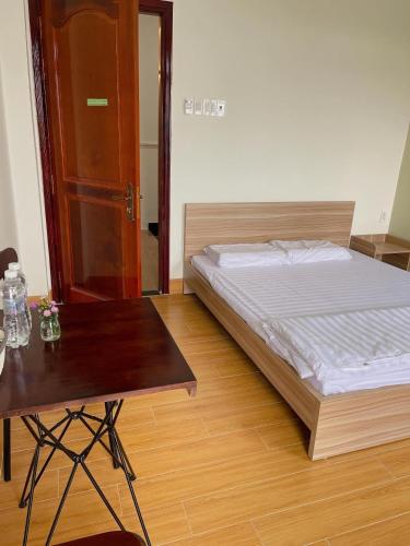 Xóm Tràm CửaNhà nghỉ Thảo Tiên的一间卧室配有一张床和一张木桌