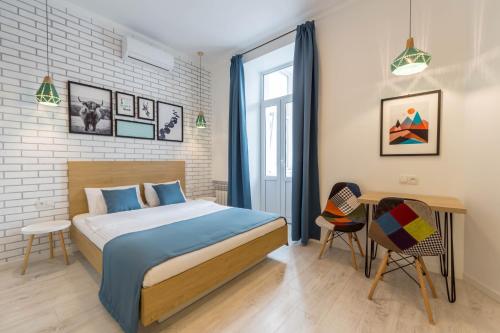 基辅Idea Design Apart-Hotel的卧室配有一张床和一张桌子及椅子