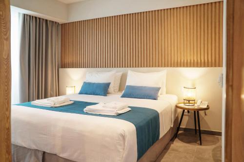 依拉佩特拉Tylissos Beach Hotel - Adults Only的卧室配有带蓝色枕头的大型白色床
