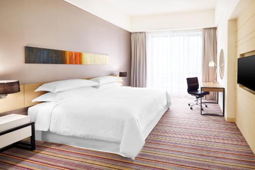 普崇蒲种福朋喜来登酒店的酒店客房设有白色的床和电视。