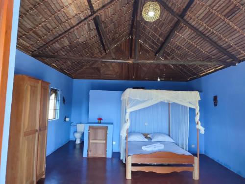 贝岛Auberge Le Lagon的一间卧室设有一张木天花板床。
