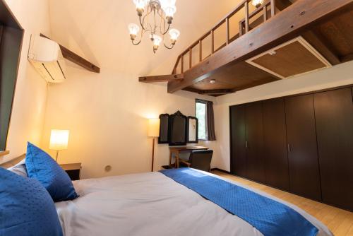 箱根HAYATO HAKONE GUEST HOUSE的一间卧室配有一张带蓝色枕头的大床
