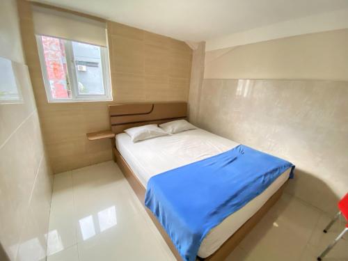 安汶Penginapan Star Ambon Mitra RedDoorz的小卧室配有一张带蓝色毯子的床