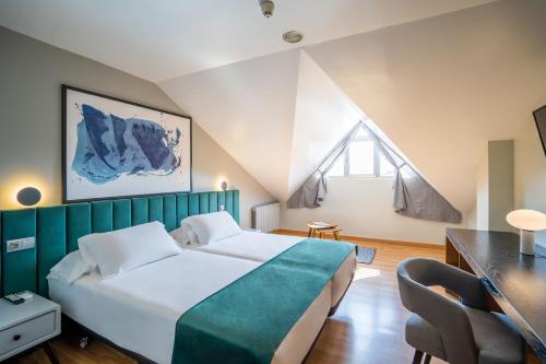 柯米拉斯Abba Comillas Hotel的一间卧室配有一张大床和绿色床头板
