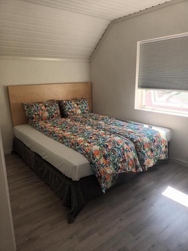 特罗姆瑟Olgas apartment的一间卧室配有一张带彩色床罩和窗户的床。