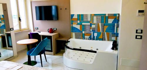 圣乔瓦尼·罗通多HOTEL HOUSE GARGANO的带浴缸、桌子和凳子的浴室