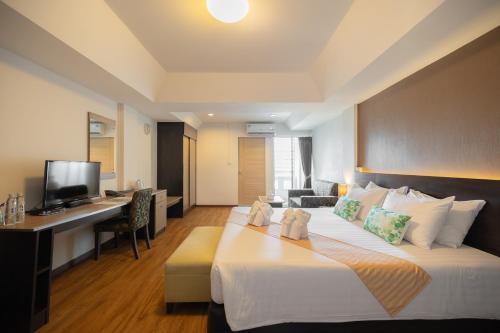 莱卡邦金玉素万那普酒店的酒店客房设有一张大床和一张书桌。