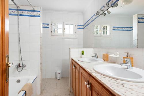 马翁Villa Cala Llonga的一间带两个盥洗盆和淋浴的浴室