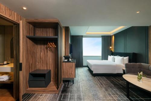 当格浪Mercure Tangerang Centre的酒店客房,配有床和沙发