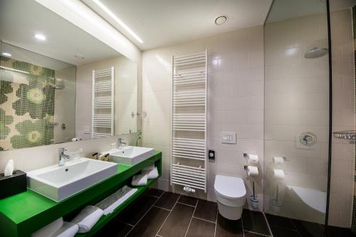 里姆斯克·托普利采Rimske Terme Resort - Hotel Rimski dvor的一间带水槽、卫生间和镜子的浴室