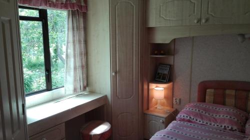 Zlatá KorunaMobilhome Camping Paradijs的一间卧室设有一张床和一个窗口