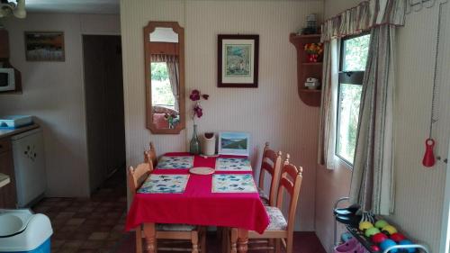 Zlatá KorunaMobilhome Camping Paradijs的一间用餐室,配有红色的桌子和椅子