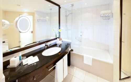 科隆科隆梅西道瑞特酒店的一间带水槽、浴缸和镜子的浴室
