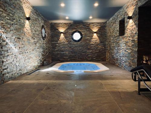 瓦尔Hôtel 16 | 150 Montagne & Spa Nuxe的砖墙内带热水浴缸的房间