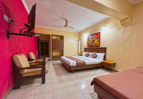 舍地Hotel Sai leela - Shirdi的配有一张床和一把椅子的酒店客房