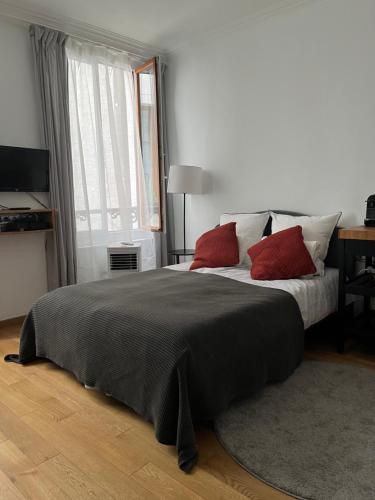 巴黎MaisonZen的一间卧室配有一张大床和两个红色枕头