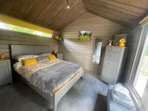 Kincardine OʼNeilDaisy Cabin的木制客房内的一间卧室,配有一张床