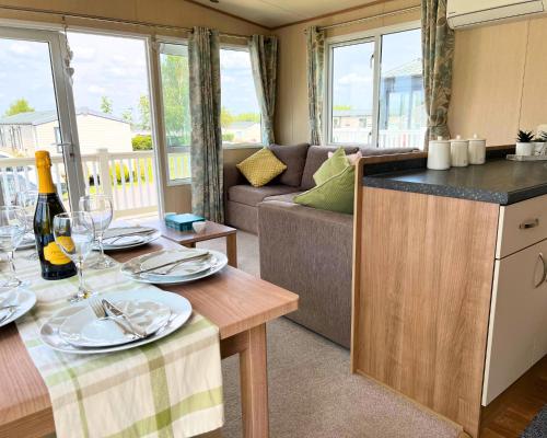 罗切斯特Haven Holiday Home at Kent Coast Allhallows的厨房以及带桌子和沙发的客厅。