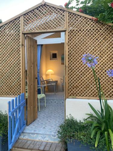 ChaucreCharming house close to the Plage des Huttes的一个带蓝色门的木制凉亭和庭院