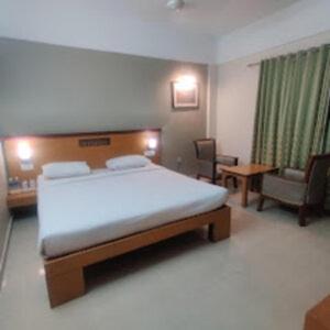 帕拉克卡德Kottaram Hotels Ottaplam的一间卧室配有一张床、一张沙发和一把椅子
