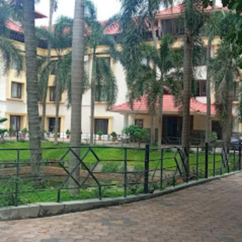 帕拉克卡德Kottaram Hotels Ottaplam的棕榈树建筑前的围栏