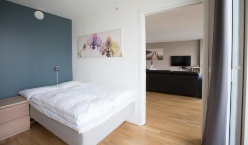 斯塔万格Klostergaarden leilighetshotell的卧室配有白色的床和蓝色的墙壁