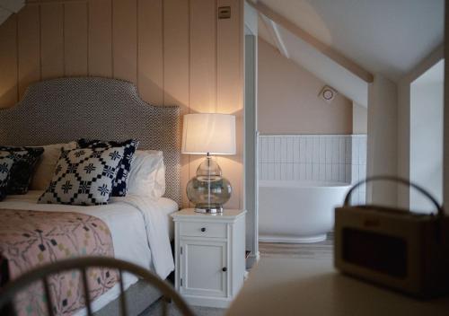 考布里奇The Bear, Cowbridge的一间卧室配有一张床、一个浴缸和一盏灯