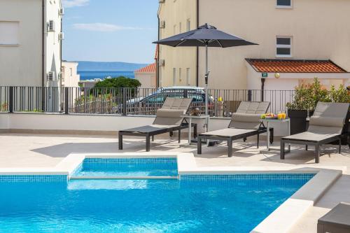 普罗马尼亚A&D Deluxe apartments Dani with swimming pool的一座带椅子和遮阳伞的游泳池
