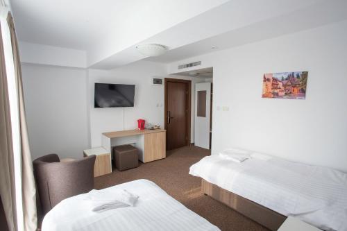 布加勒斯特Acomodoro Residence的酒店客房配有两张床和一张书桌
