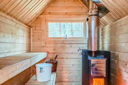 萨拉Karhunkierros Cabins & Huts的小木屋设有炉灶和窗户。