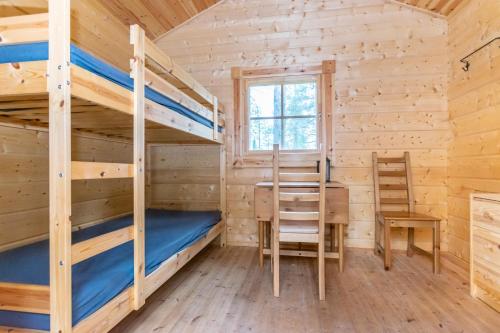 萨拉Karhunkierros Cabins & Huts的小屋设有两张双层床和一张书桌