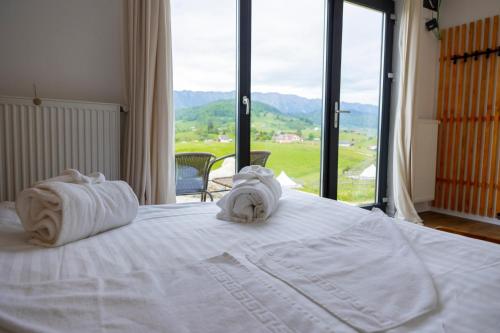 锡尔内亚Ursa Mica Glamping Resort的一间卧室配有带毛巾的床