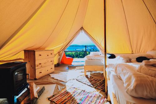 锡尔内亚Ursa Mica Glamping Resort的帐篷配有两张床和炉灶