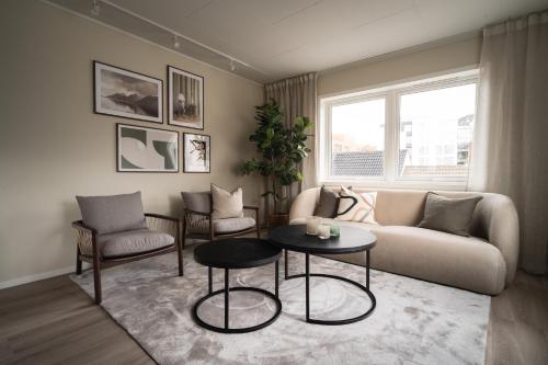 特罗姆瑟Enter Viking Apartment Hotel的客厅配有沙发、椅子和桌子