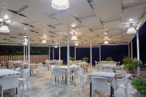 耶尼翁Menes Hotel的餐厅配有白色的桌椅和灯光