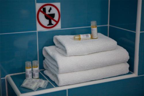 耶尼翁Menes Hotel的浴室架子上的毛巾堆