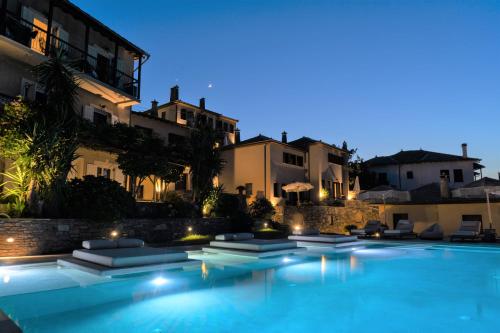 阿吉奥斯伊欧尼斯阿加皮托斯别墅宾馆的一座游泳池,在晚上在建筑物前