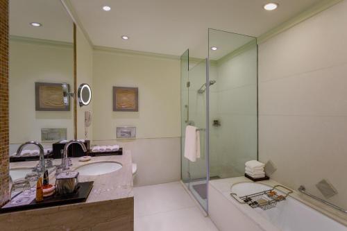 新德里ITC Maurya, a Luxury Collection Hotel, New Delhi的一间带两个盥洗盆和淋浴的浴室
