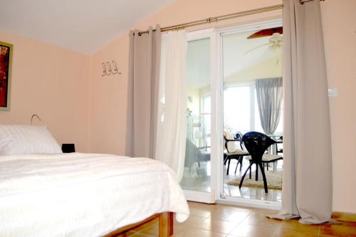 普莱克Wohnung mit Meerblick Romy的一间卧室设有一张床和一个滑动玻璃门