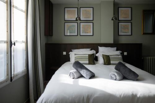 沙特尔LeParticulier - L'Amiral的卧室配有带枕头的白色床和窗户。