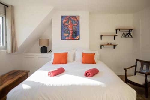 沙特尔LeParticulier - L'Amiral的卧室配有带红色枕头的大型白色床