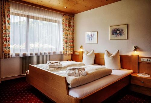 达米尔斯Pension Uga的一间卧室设有一张大床和窗户