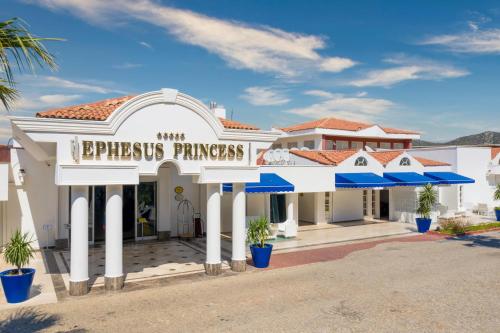 库萨达斯Labranda Ephesus Princess - All Inclusive的前面有蓝色伞的白色建筑