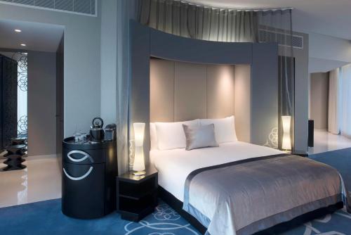 多哈W Doha的一间卧室配有一张大床和大床头板